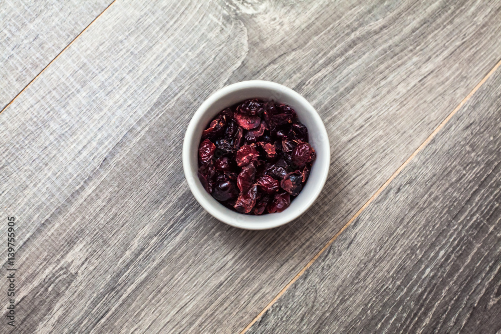 Dried Cranberries in a bowl on a wooden table Dried Cranberries in a bowl on a wooden table