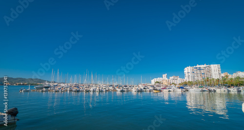Boats, small yachts & water craft of all size in marina of Sant Antoni De Portmay.   Morning of warm sunny day in the harbour.  Bright town of  Sant Antoni de Portmany, Balearic Islands, Spain. © valleyboi63