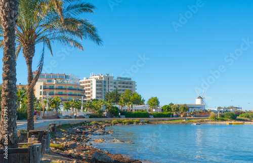 Ibiza sunshine on the waterfront in Sant Antoni de Portmany,  Take a walk along the main boardwalk, now a stone concourse beside the beach.  Places to stay in Ibiza.  photo