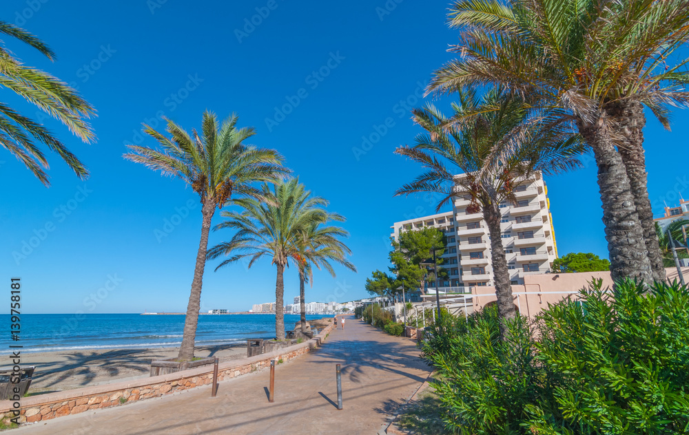 Fototapeta premium Ibiza sunshine on the waterfront in Sant Antoni de Portmany, Take a walk along the main boardwalk, now a stone concourse beside the beach. Places to stay in Ibiza. 