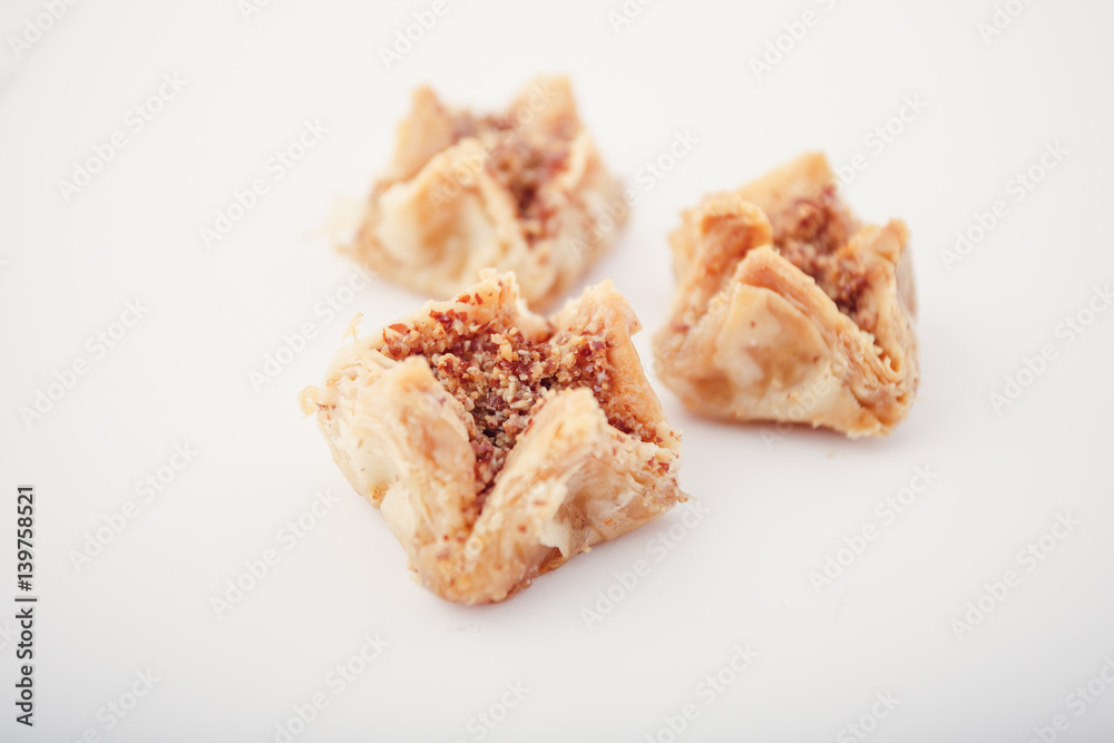 Arabian Eid dates sweets isolated. Oriental sweets with honey and nuts. Turkish Pakhlava Isolated On White. Turkish dessert. Arabian Eid dates sweets isolated. Oriental sweets with honey and nuts. Turkish Pakhlava Isolated On White. Turkish dessert.