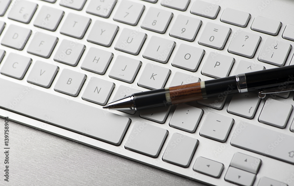 Ballpoint pen on a computer keyboard. Technology. Horizontal shoot. Ballpoint pen on a computer keyboard. Technology. Horizontal shoot.