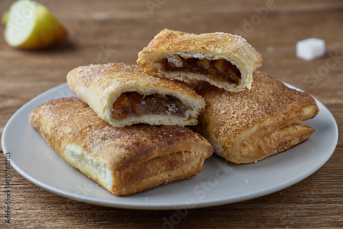 Delicious puff pastry with apples on a wooden background