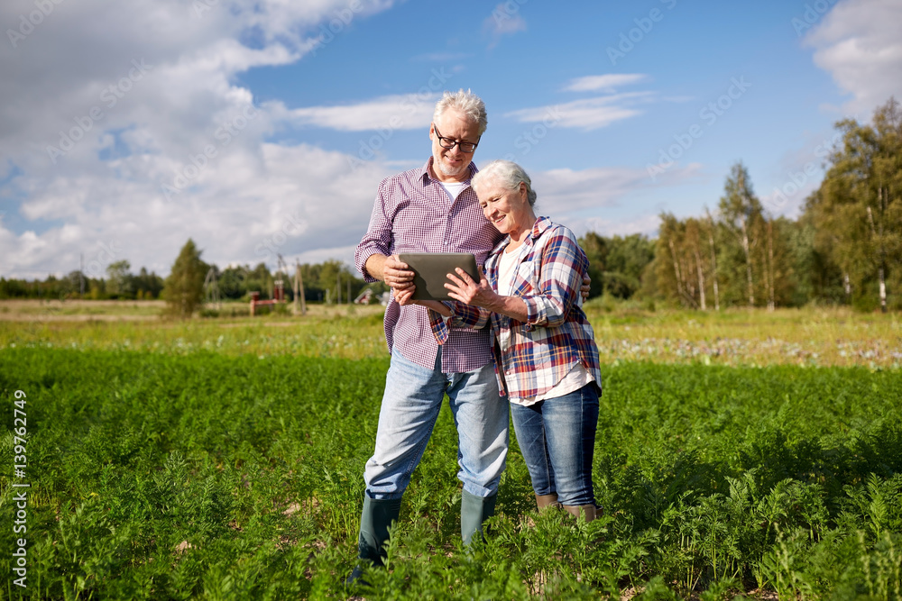 happy senior couple with tablet pc at summer farm happy senior couple with tablet pc at summer farm