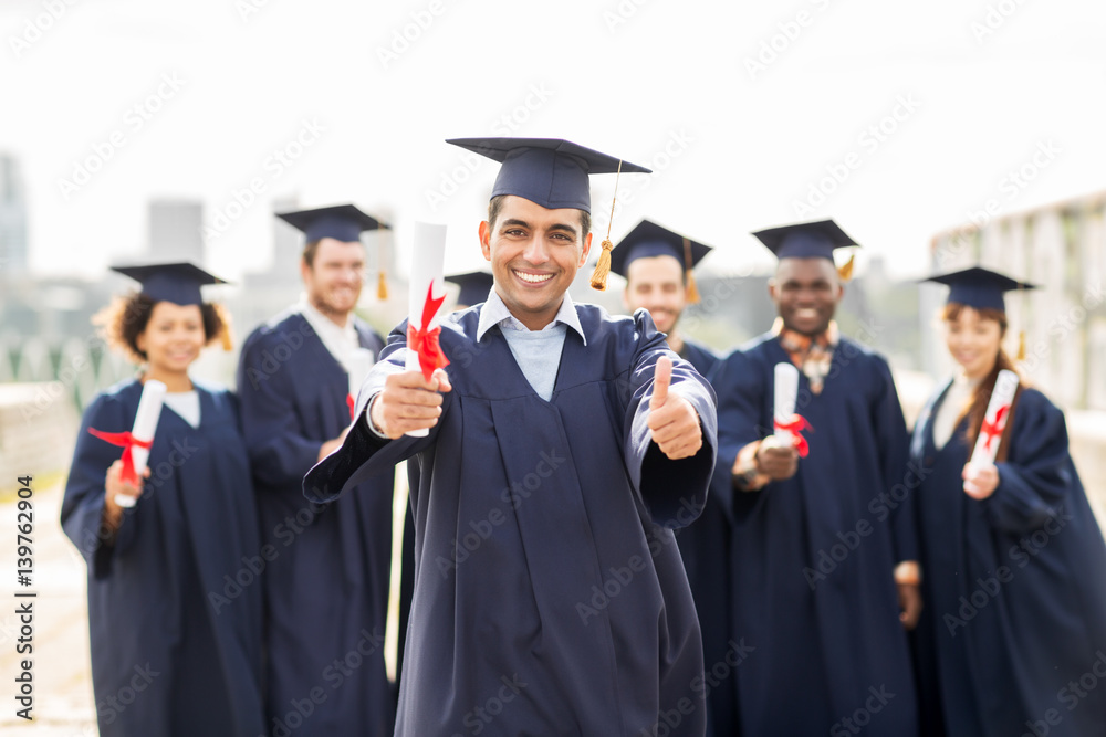 happy students with diplomas showing thumbs up happy students with diplomas showing thumbs up