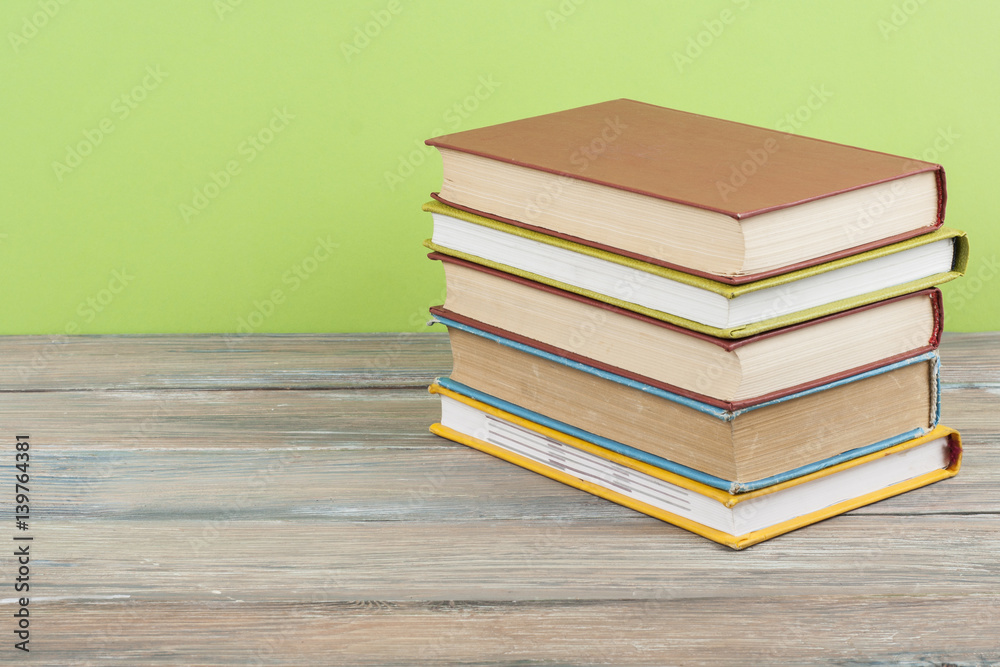 Stack of colorful books on wooden desk, free copy space. Back to school. Education background