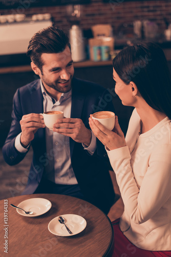 Happy romantic man and woman  sitting in a cafe drinking coffee photo