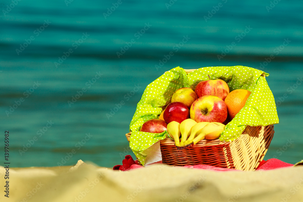 Picnic basket on blanket near sea