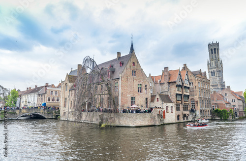 BRUGES, BELGIUM - MARCH 2015: Tourists visit ancient medieval city on a cloudy day. Brugge attracts more than 2 million people annually