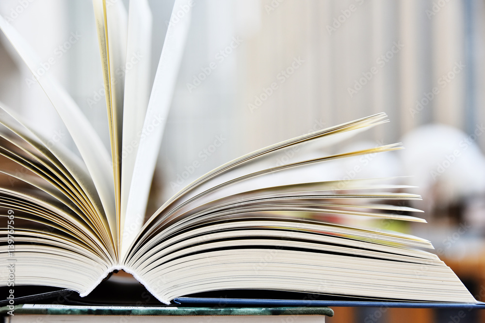 Fototapeta premium Hardcover book lying on the table in the library