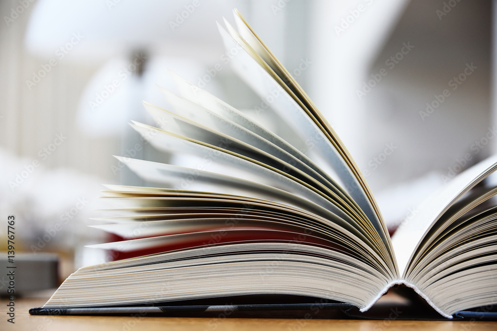 Fototapeta premium Hardcover book lying on the table in the library