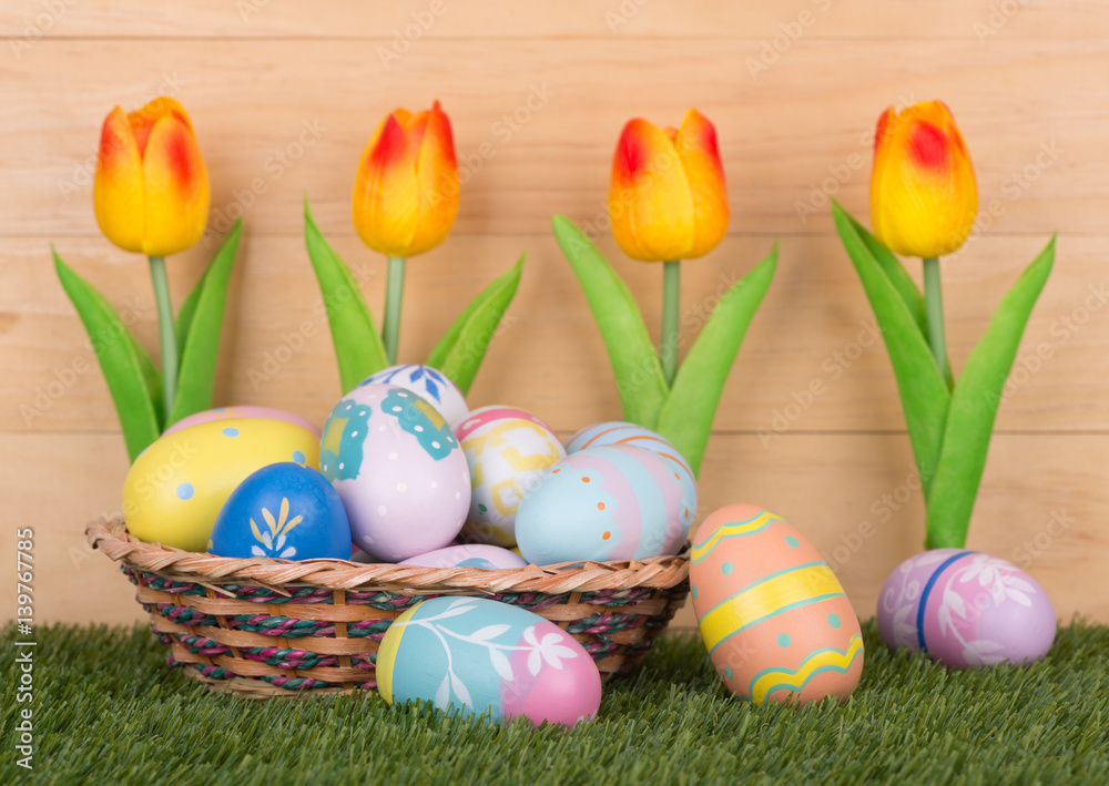 Fototapeta premium Colorful Easter Eggs and Tulips Against a Wooden Background