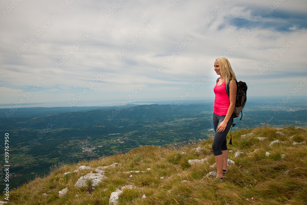 Trekking - woman hiking in mountains on a calm sumer day