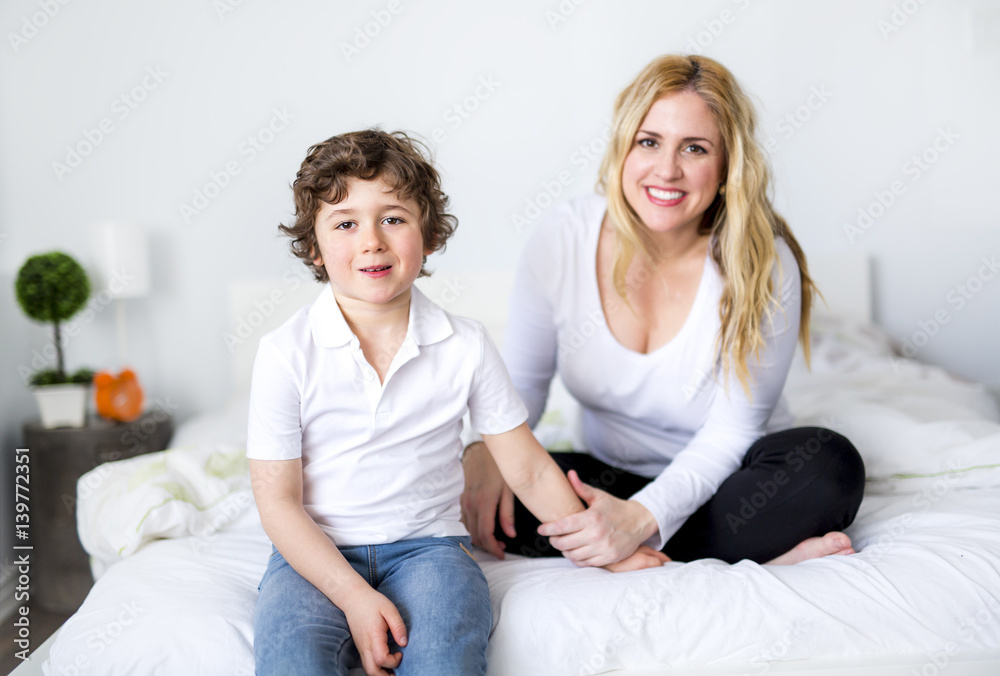 Beautiful young mother and son lying together on a bed Beautiful young mother and son lying together on a bed
