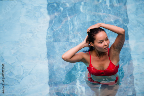 Enjoying vacation. Smiling beautiful young woman in swimming pool.