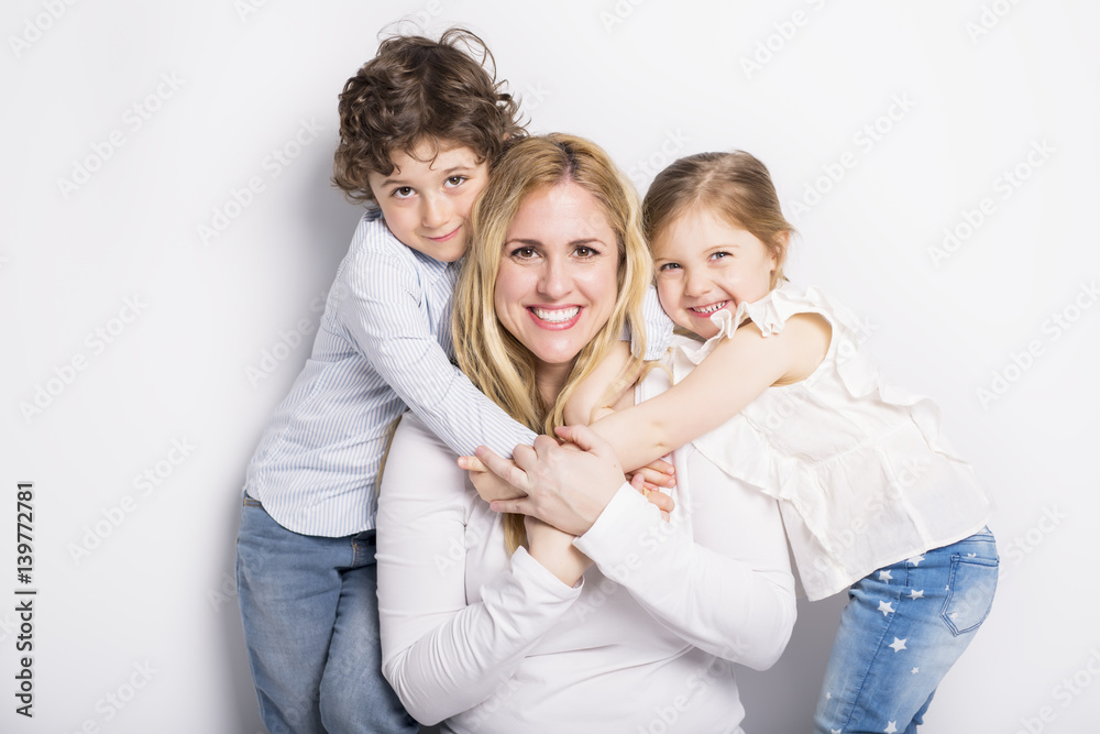 mother, her son and daughter in front of white background mother, her son and daughter in front of white background