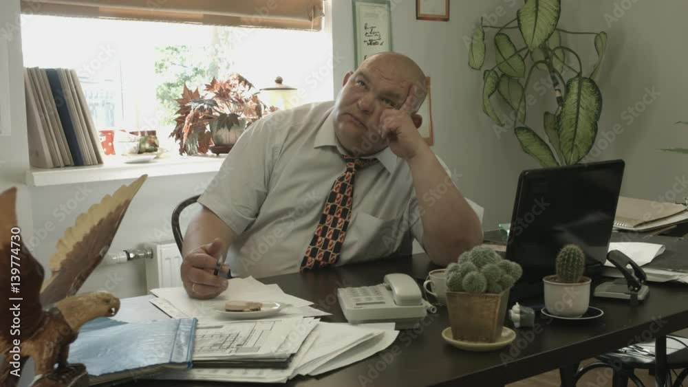 Ungraded: Boss Desk / Manager Office / Boss Doing Nothing / Creative Thinking / No Ideas. Funny fat chief is out of ideas. Man puts the paper sheet aside and begins to dream in the workplace.