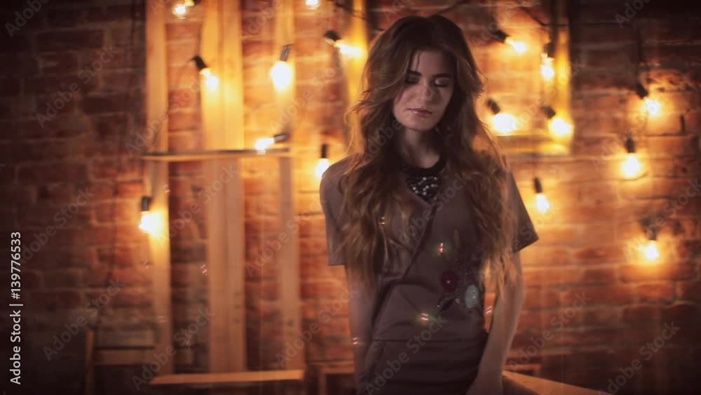 girl on the background of electric lamps and brick wall girl on the background of electric lamps and brick wall