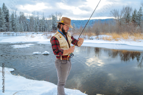 Fisherman Fly Fishing in the Winter Snow photo