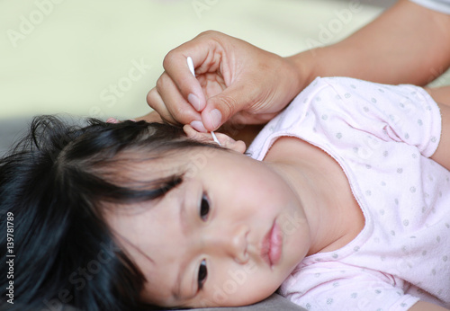 Mother Cleaning Baby Ear With cotton swab.