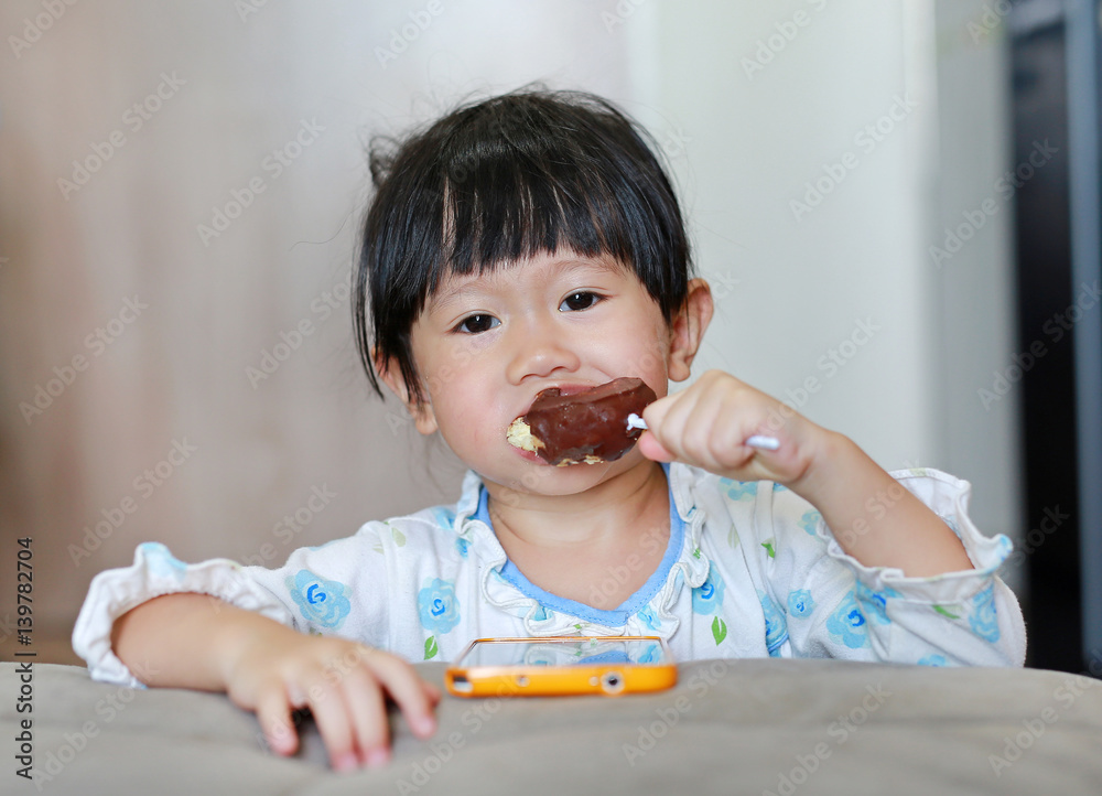 smiling-asian-baby-girl-2-year-old-eating-donut-in-room-childhood