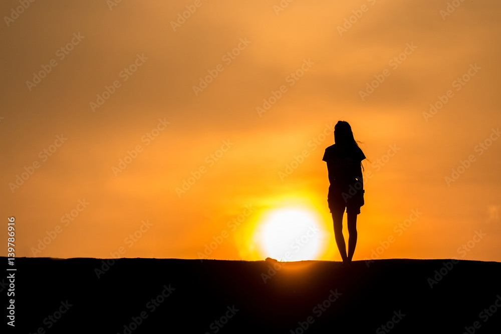 silhouette of Young woman relaxing in summer sunset sky outdoor. People freedom style.