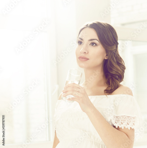 Beautiful  young woman with glass of water. Relaxing at home.