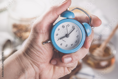 Morning alarm concept - hand with clock