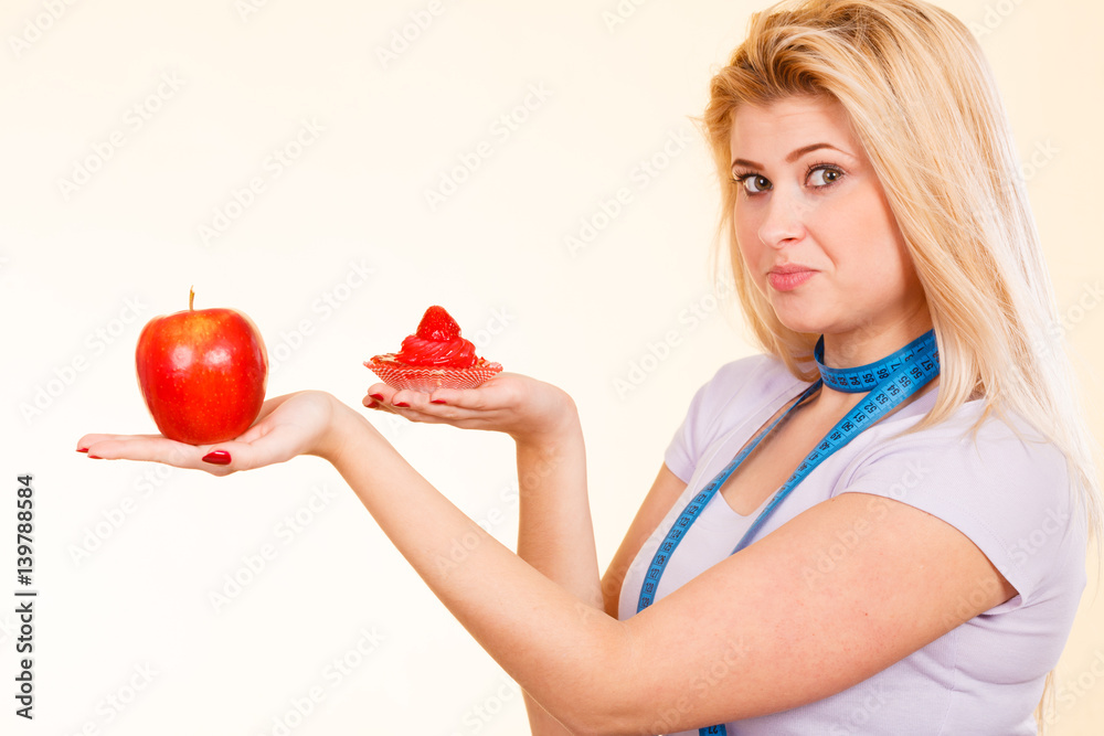 Woman with measuring tape choosing what to eat Woman with measuring tape choosing what to eat