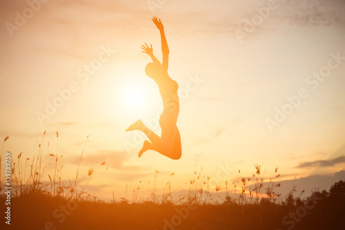 Silhouette of woman praying over beautiful sky background