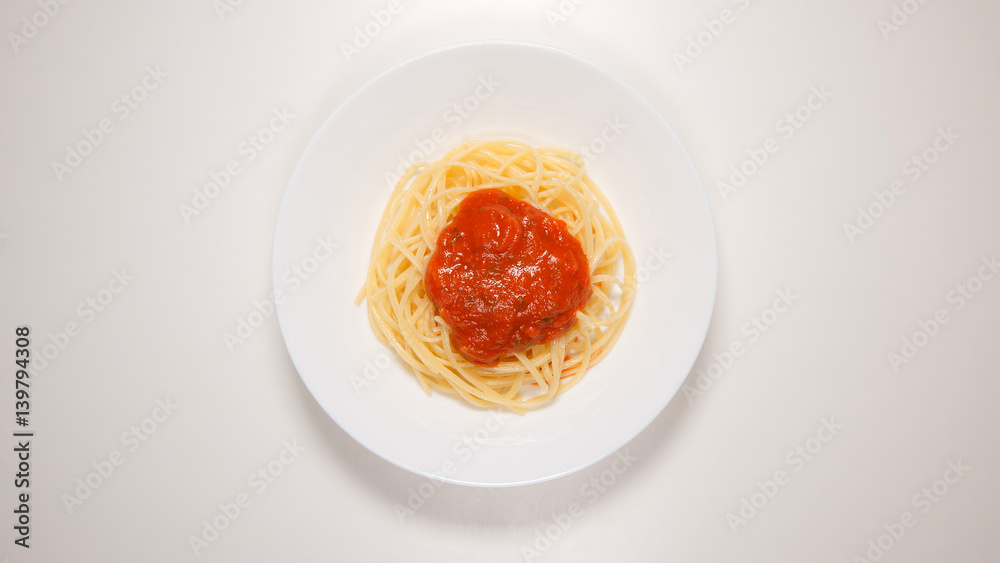 TOP VIEW: Spaghetti with tomato sauce on a white dish TOP VIEW: Spaghetti with tomato sauce on a white dish