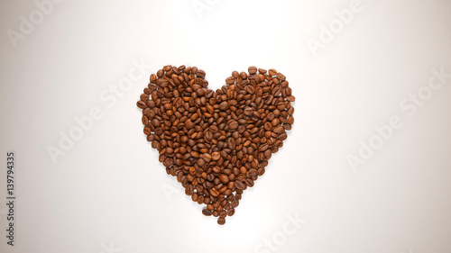 TOP VIEW: Heart symbol from a coffee beans on a white table
