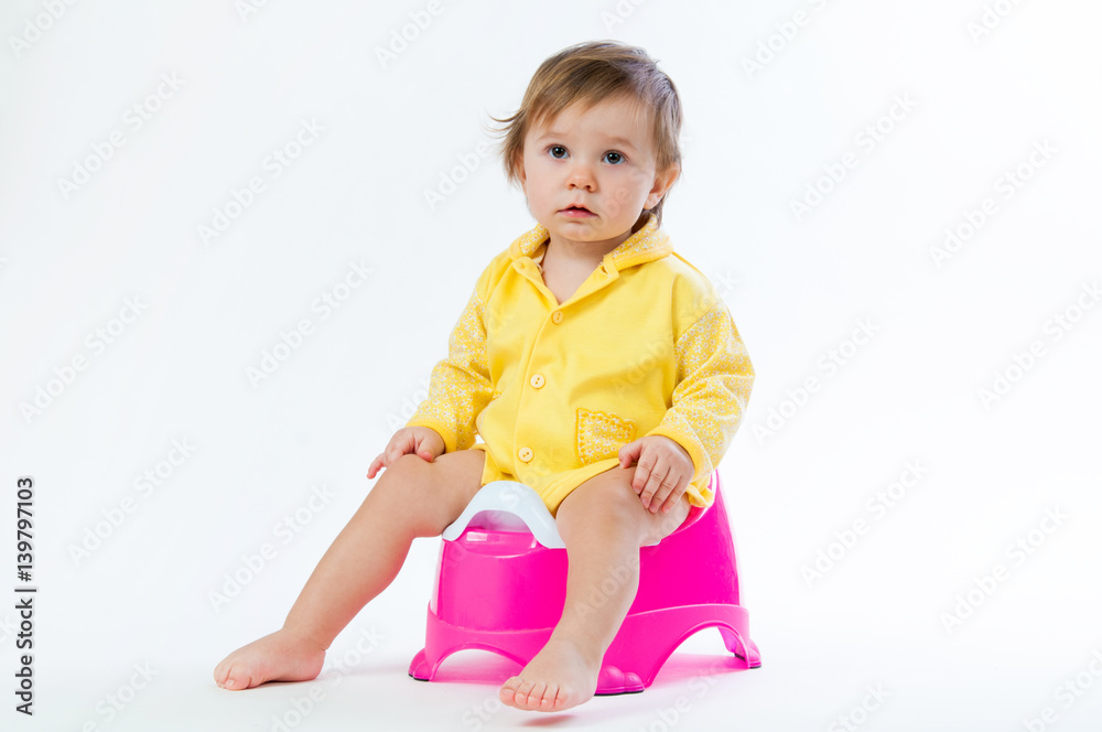 Little smiling girl sitting on a pot. Isolated on white background ...