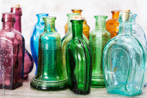 Coloured glass bottles on a rustic background