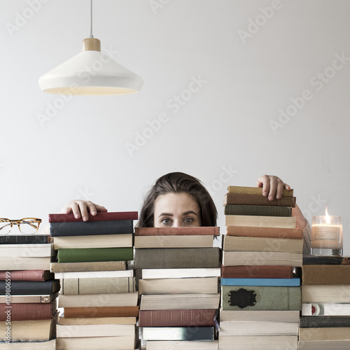 Person swamped hiding in piles of books