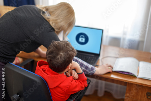 Mother locking on computer for son, parental control photo