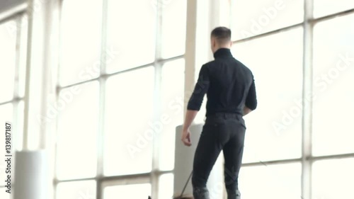 A man riding a brown horse around the arena. Man fulfills tricks on horseback. Vaulting. Trick riding. Riding standing on horse. Close up.