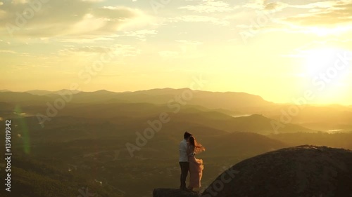 Lover Couple in the top of mountains with orange sunrise 