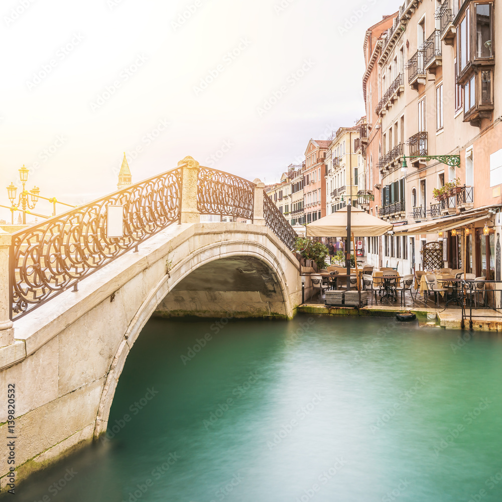 long time exposure of a typical venetian bridge over a canal, Venice, Italy, Europe, Retro style with lens flare