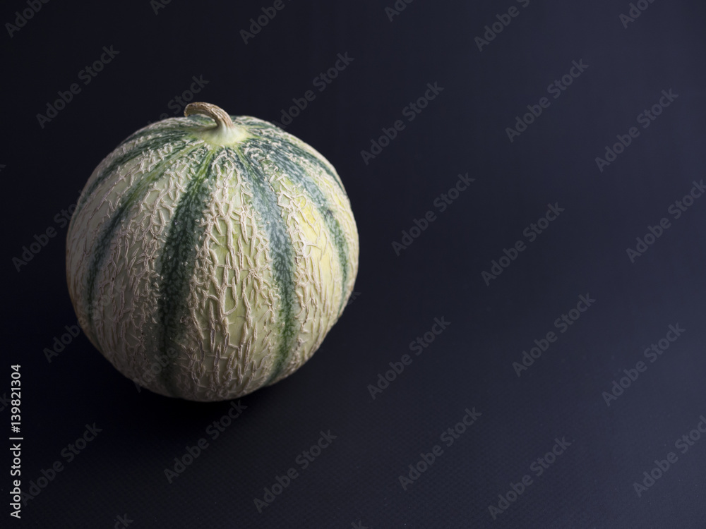 Cantaloupe melon isolated on dark background Cantaloupe melon isolated on dark background