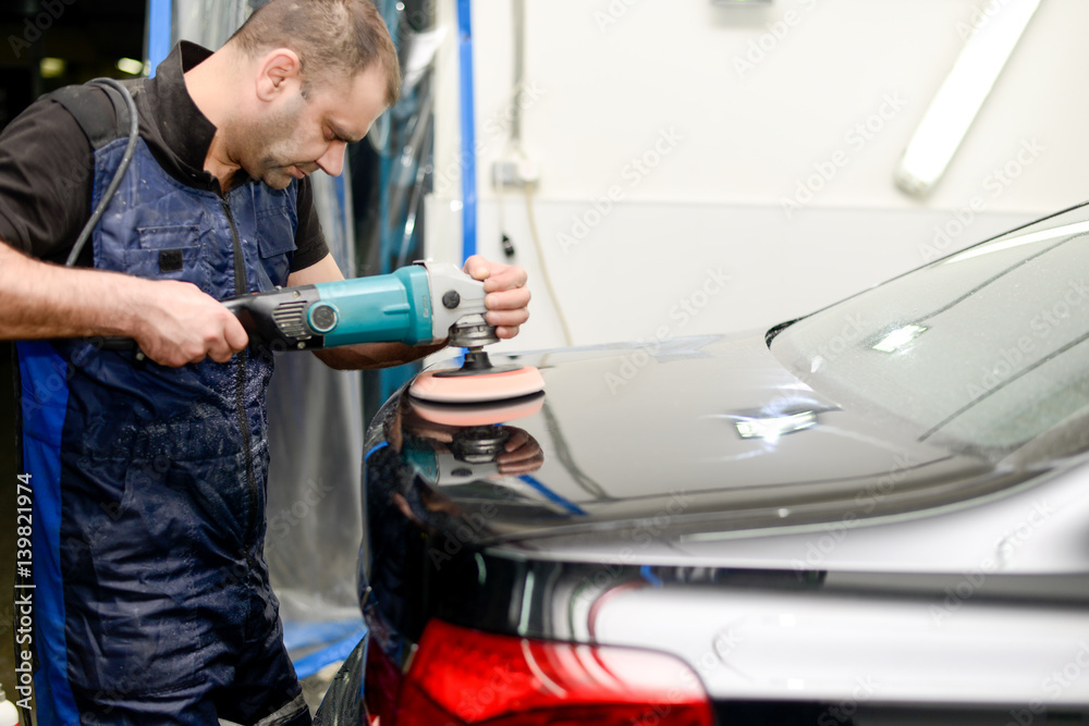 Man on a car wash polishing car with a polish machine Man on a car wash polishing car with a polish machine