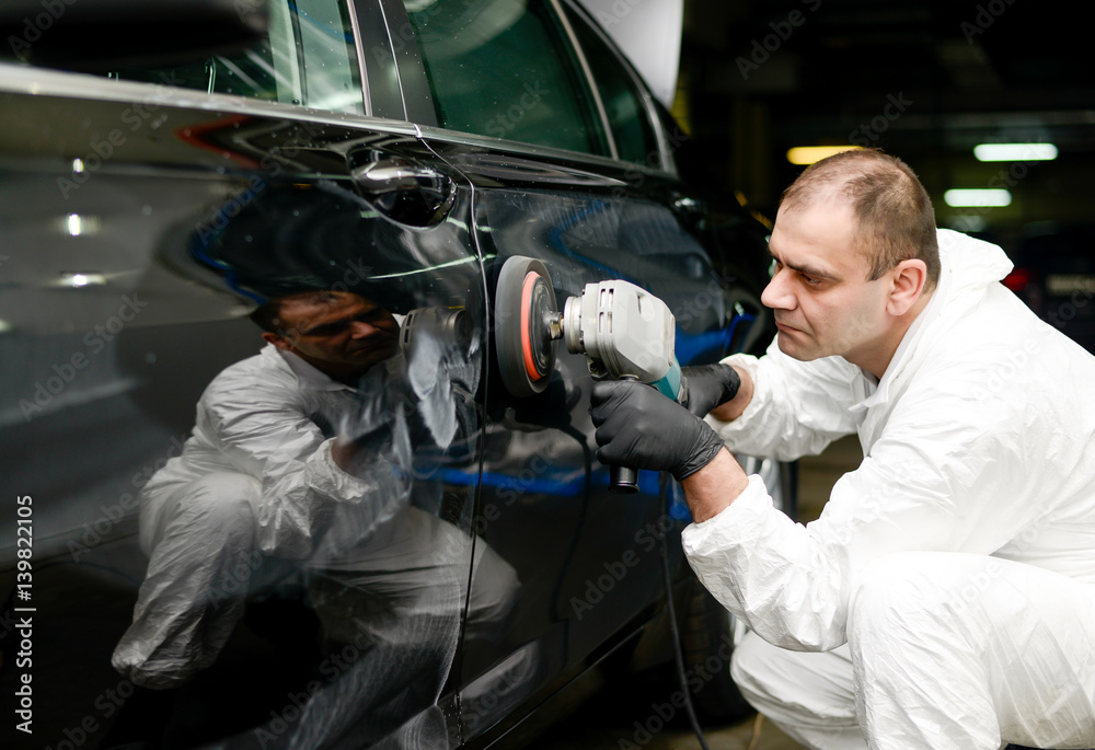 Man on a car wash polishing car with a polish machine Man on a car wash polishing car with a polish machine