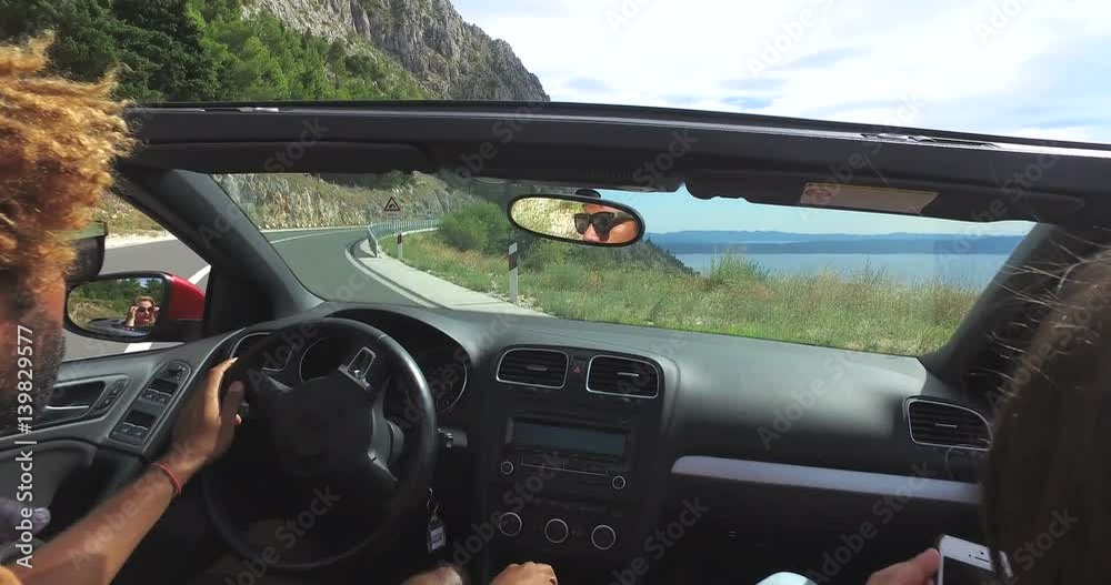 Handsome black man turning on a highway in convertible car Handsome black man turning on a highway in convertible car