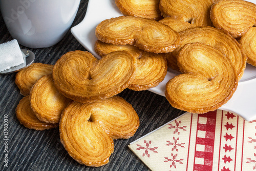 Gâteaux palmiers sur fond sombre avec tasse et sucre