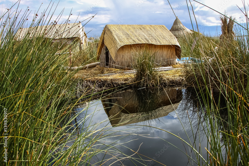 Traditional reed hut on a floating island with reflections, Islas es ...