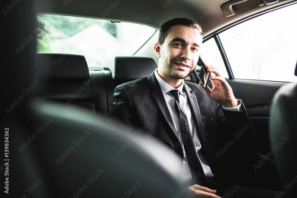 Businessman on call in car, smiling Businessman on call in car, smiling