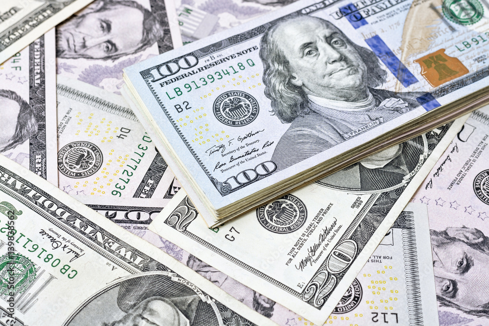 A stack of one hundred dollar bills on a background of dollars A stack of one hundred dollar bills on a background of dollars