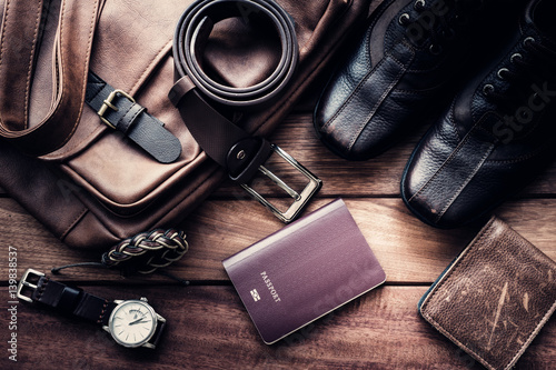 Still life with Men's casual outfits with leather accessories on brown wooden background, beauty and fashion, travel concept photo