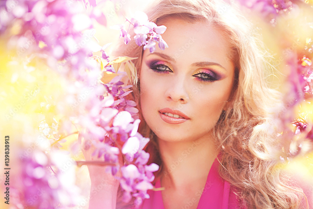 Beautiful girl in lilac dress in flower garden