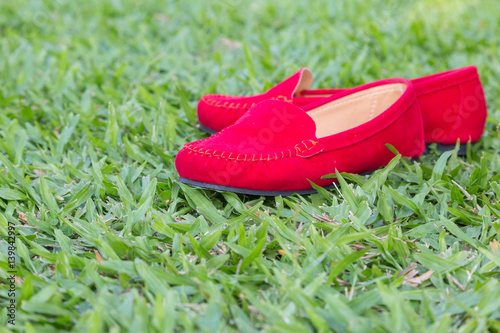 Red shoes girl on green grass background